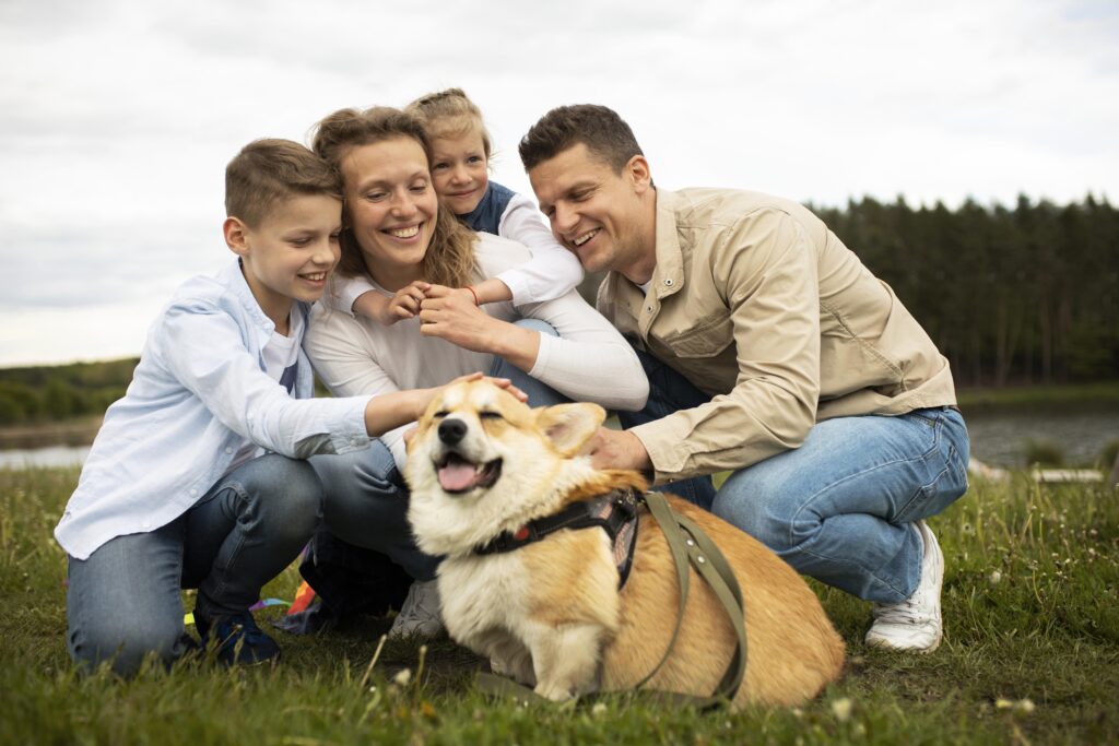 Family interacting with a Corgi therapy dog outdoors for emotional support