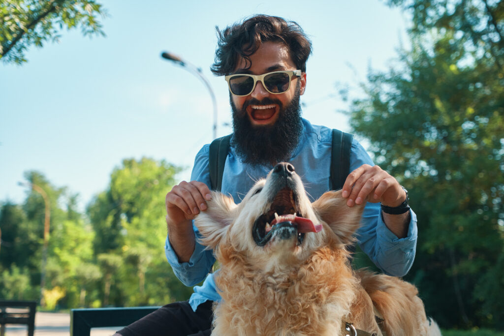 Animal-assisted therapy: Man enjoying playful moments with a therapy dog, highlighting the emotional benefits of AAT.