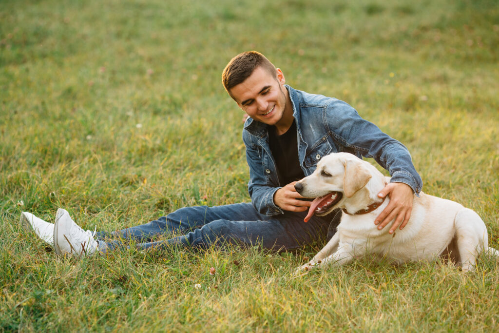 Man sitting in a park with his emotional support Labrador, providing comfort and companionship.