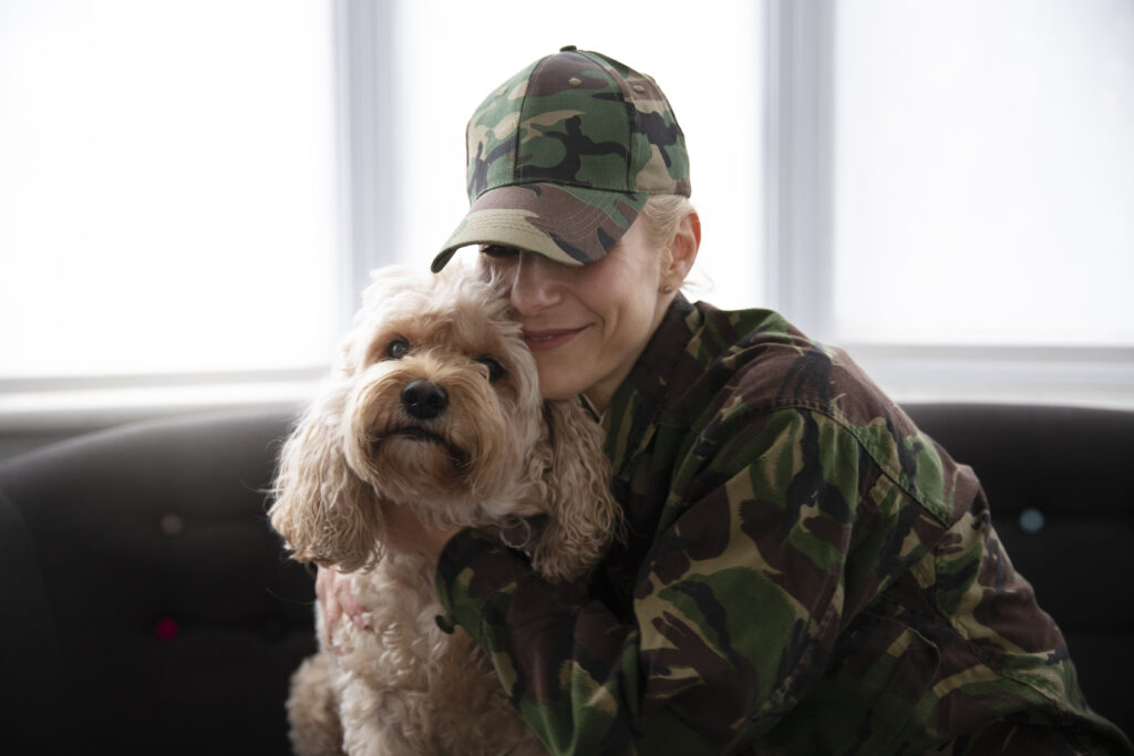 Veteran with service dog smiling together, showcasing the emotional support and bond between veterans with PTSD and their therapy animals.