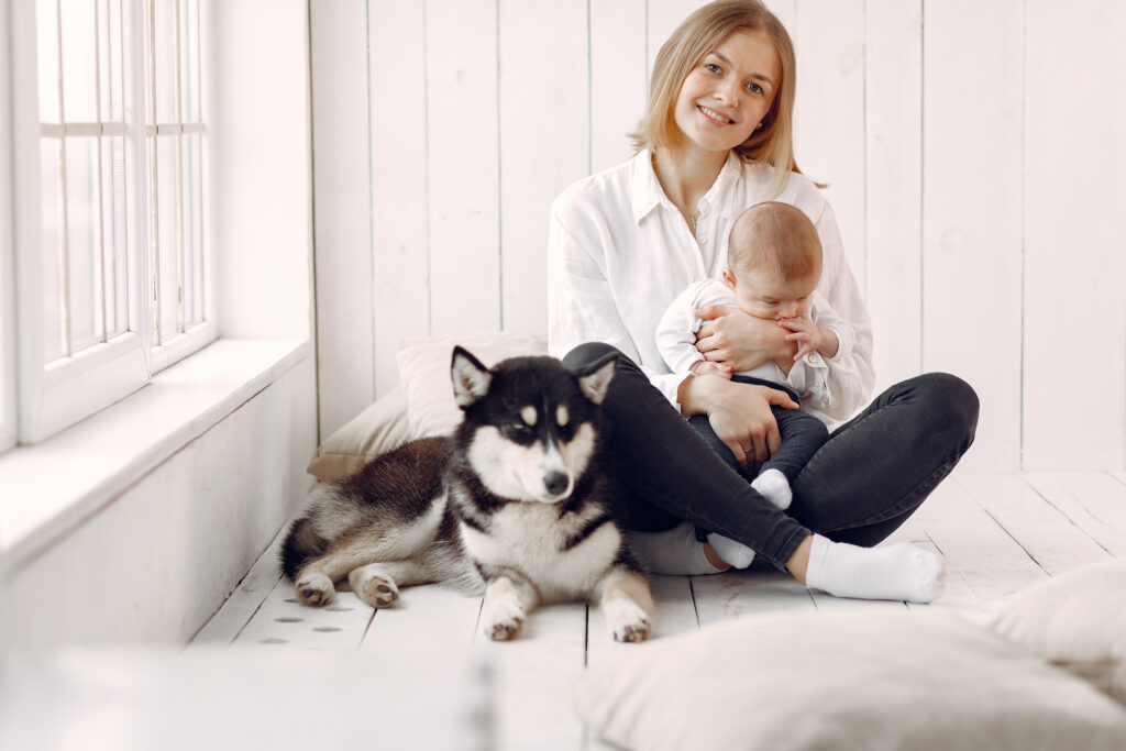 New mother with baby and therapy dog at home, providing emotional support in postpartum psychosis treatment and enhancing well-being.