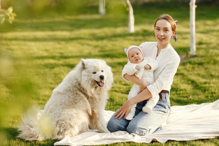 "New mother with baby and therapy dog in the garden, offering emotional support in postpartum psychosis treatment and promoting well-being."