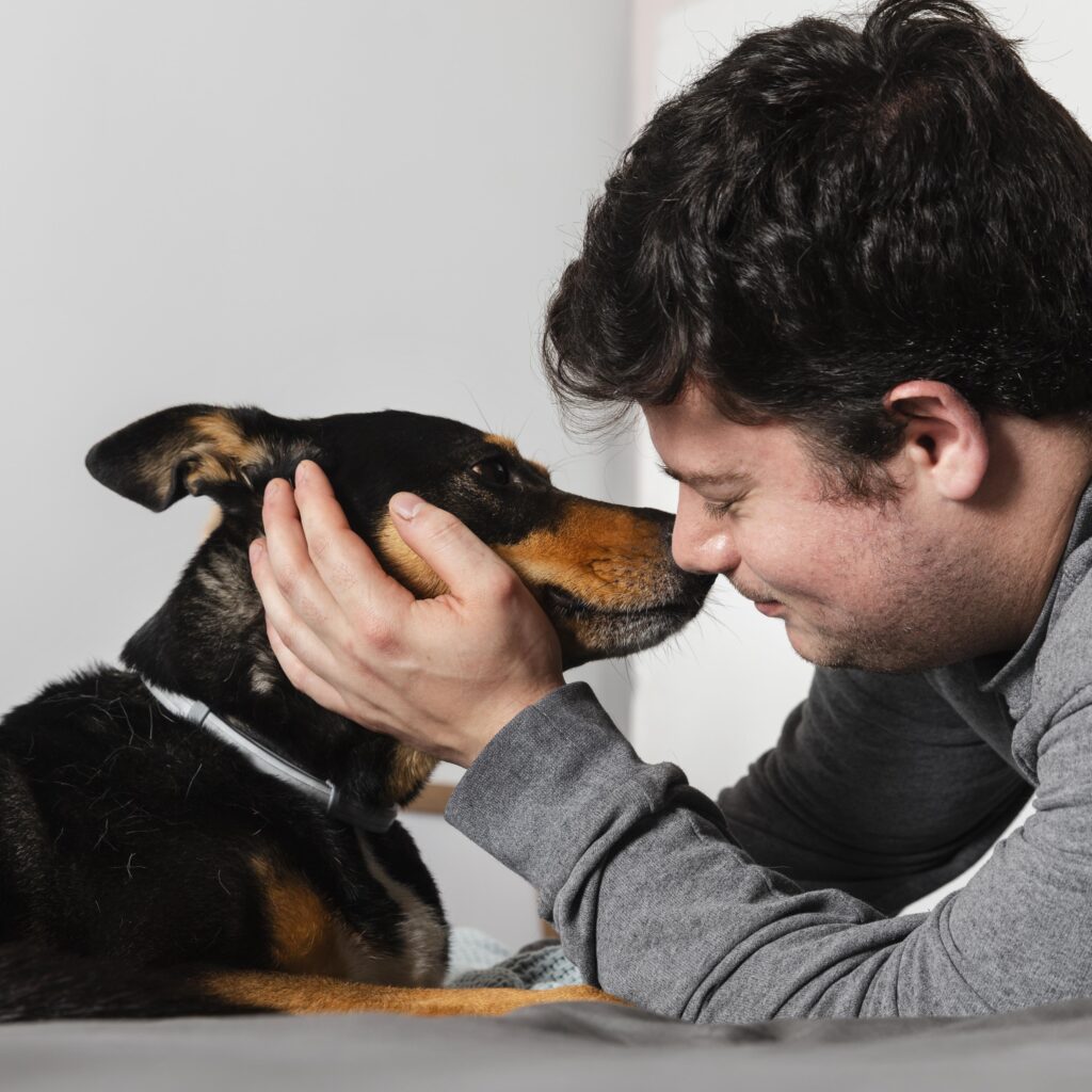 A close-up of a man and his dog touching foreheads, showcasing their strong bond