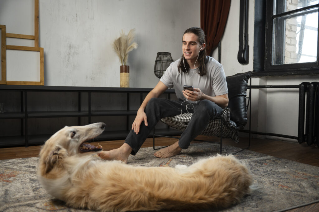 A man sitting and talking with his greyhound dog in a modern living room